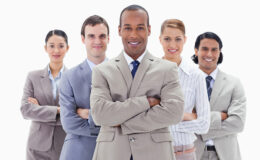 Close-up of a business team smiling and crossing their arms against white background